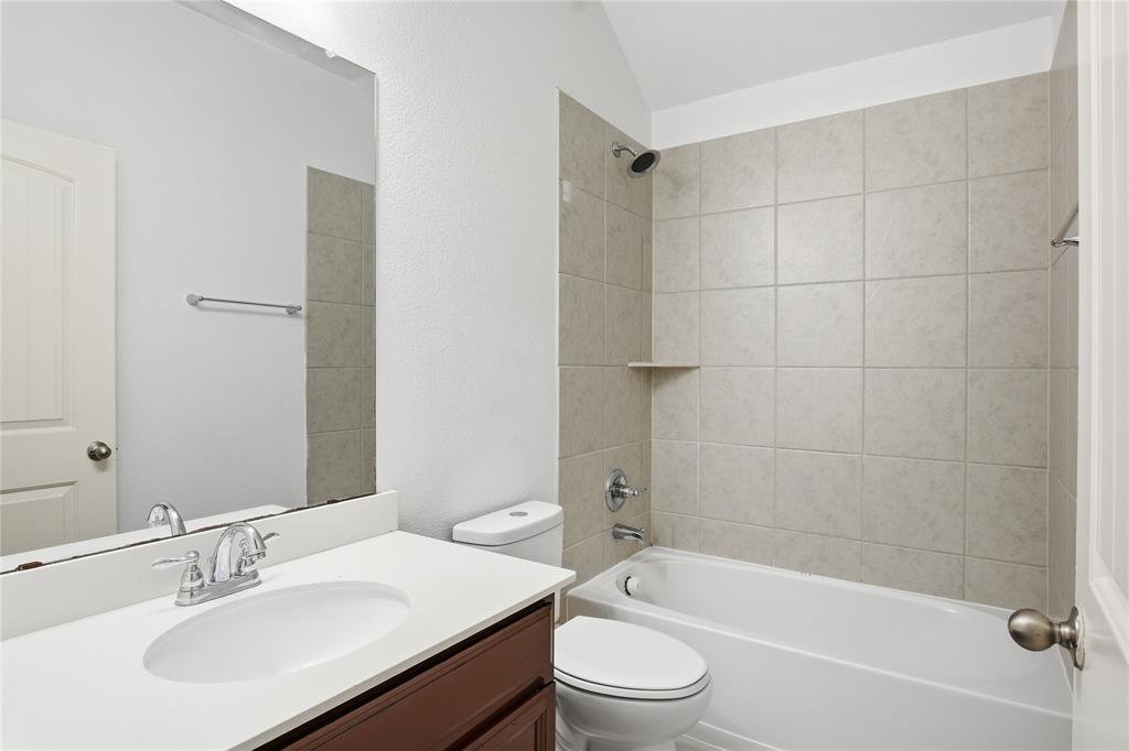 339 Blanco Drive Forney, TX 75126 - Photo 6 of 24 Bathroom with tub / shower combination, vanity, lofted ceiling, and a textured wall