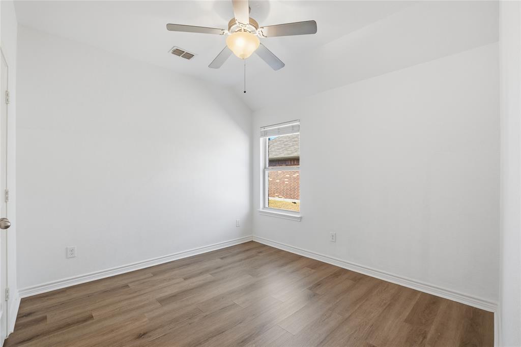 339 Blanco Drive Forney, TX 75126 - Photo 7 of 24 Empty room with vaulted ceiling, wood finished floors, and ceiling fan