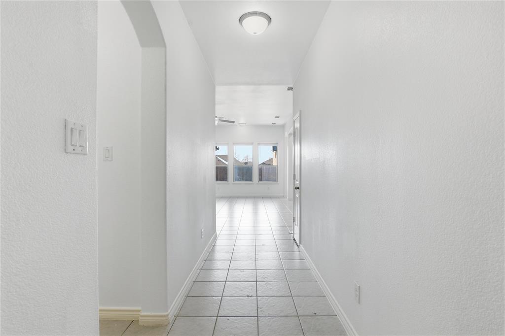 339 Blanco Drive Forney, TX 75126 - Photo 8 of 24 Corridor with a textured wall, light tile patterned floors, and arched walkways