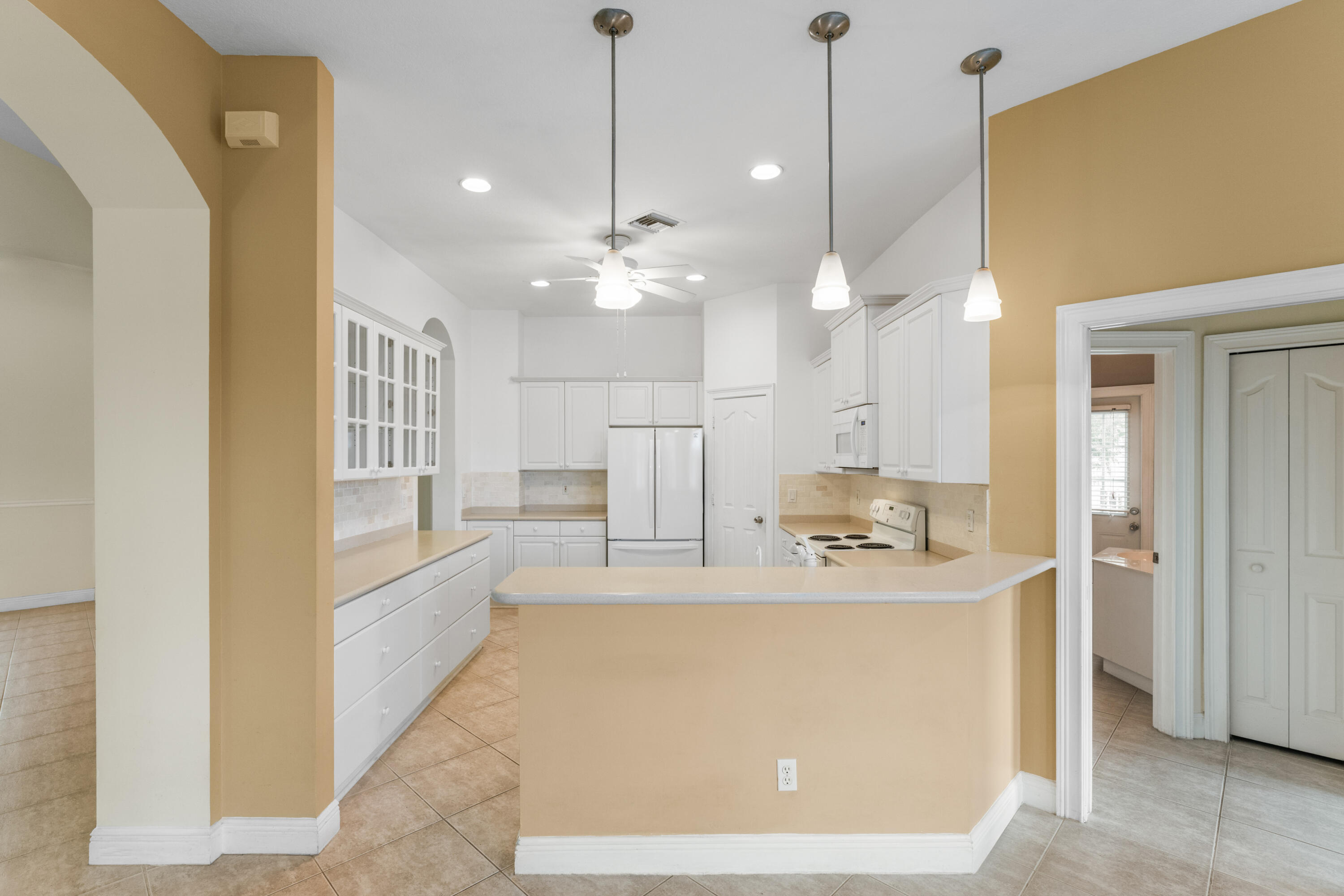 918 Southwest Blue Stem Way Stuart, FL 34997 - Photo 11 of 47 a view of a kitchen with kitchen island a sink stainless steel appliances and cabinets