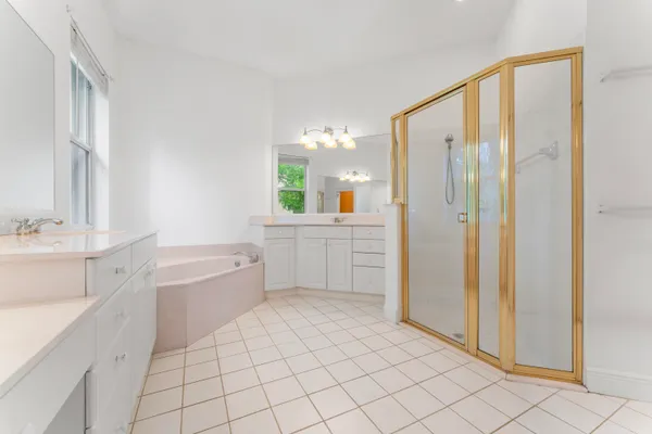 a spacious bathroom with a mirror a sink and a bathtub