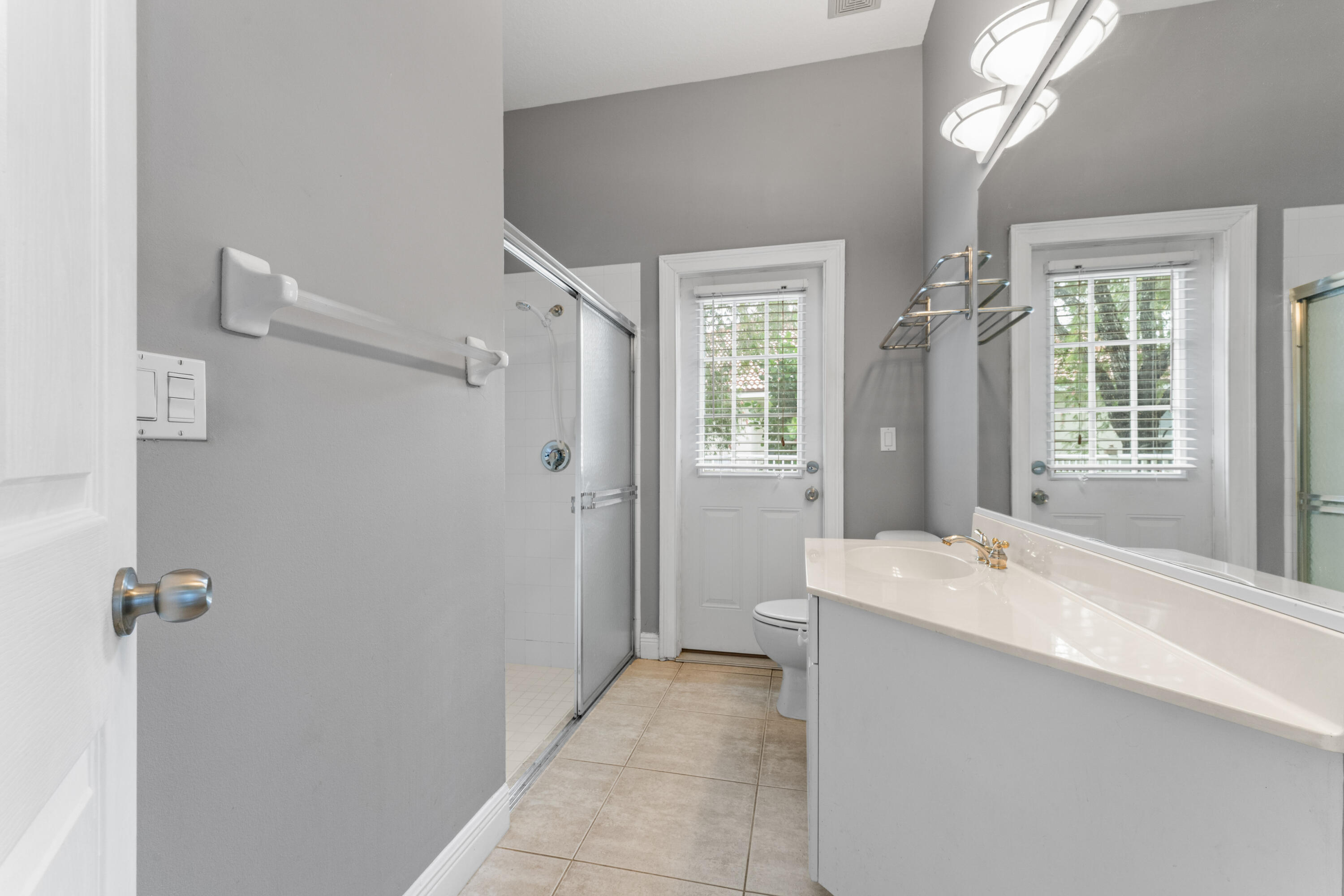918 Southwest Blue Stem Way Stuart, FL 34997 - Photo 28 of 47 a spacious bathroom with a bathtub sink and mirror