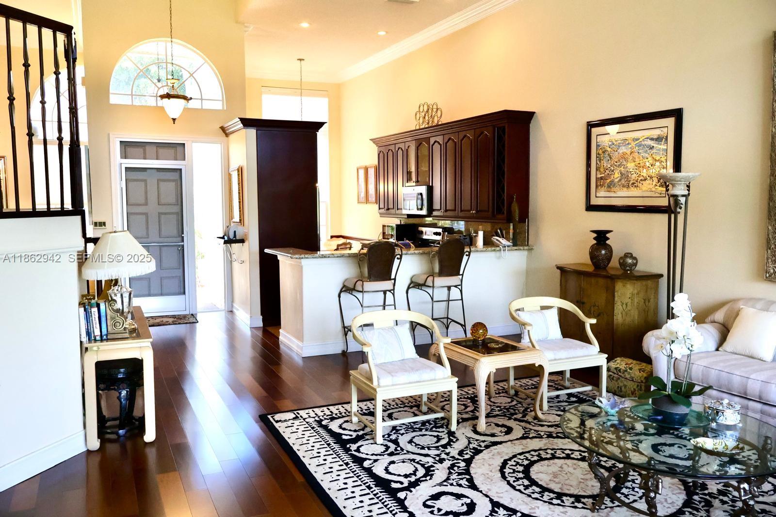 17246 Boca Club Boulevard, Unit 102 Boca Raton, FL 33487 - Photo 11 of 50 a dining room with wooden floor a chandelier a wooden table and chairs