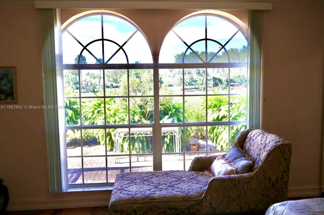 a living room with a large window and a bed