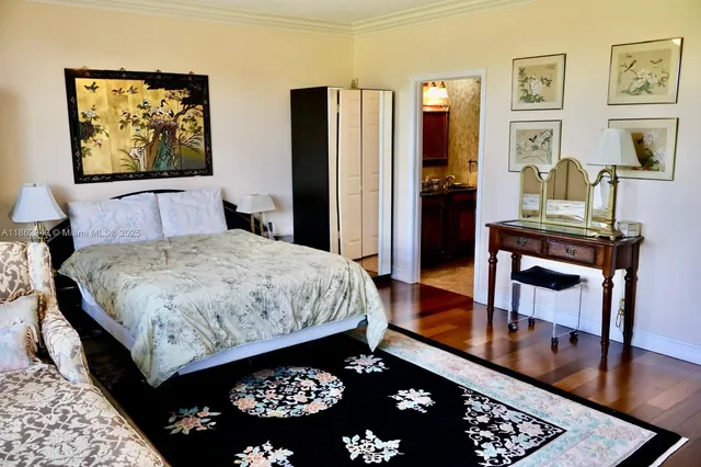 a bedroom with a bed dresser and a large mirror on a dresser