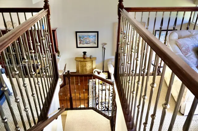 a view of staircase with railing and white walls