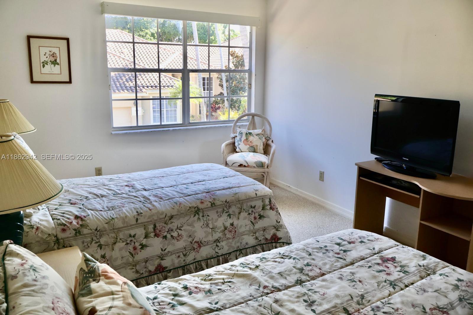 17246 Boca Club Boulevard, Unit 102 Boca Raton, FL 33487 - Photo 33 of 50 a bedroom with a bed and a flat screen tv