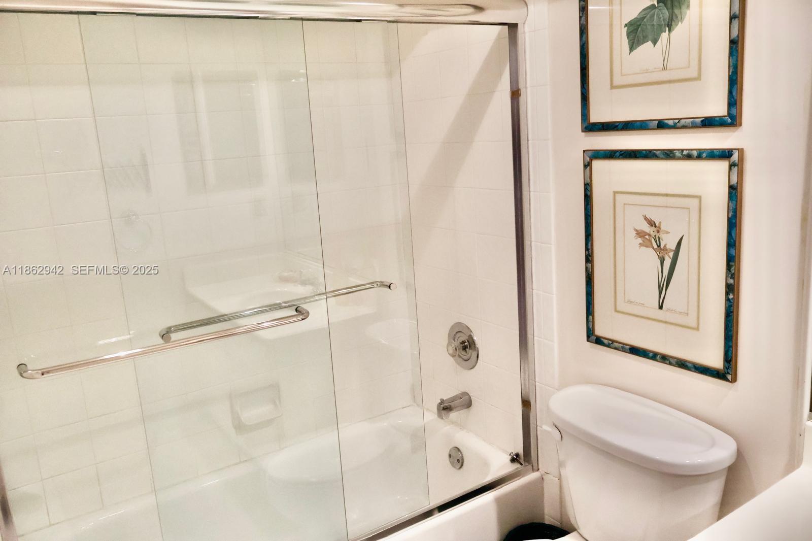 17246 Boca Club Boulevard, Unit 102 Boca Raton, FL 33487 - Photo 35 of 50 a bathroom with a shower curtain and a toilet