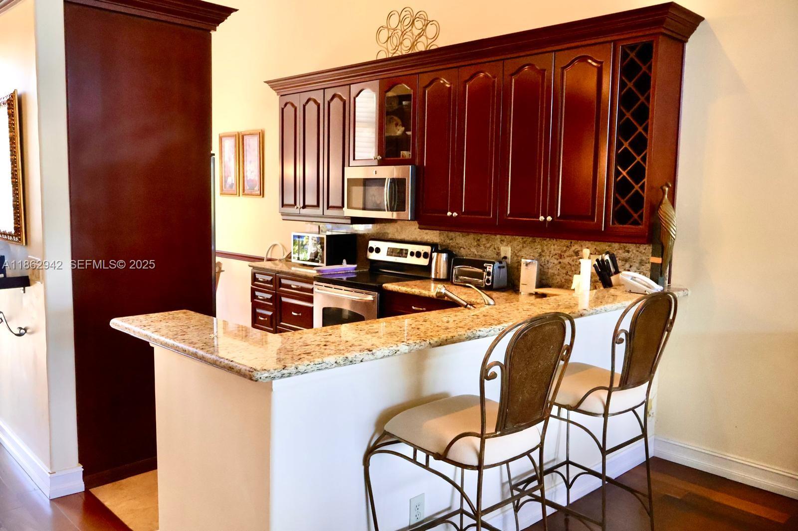 17246 Boca Club Boulevard, Unit 102 Boca Raton, FL 33487 - Photo 9 of 50 a kitchen with a sink a table and chairs