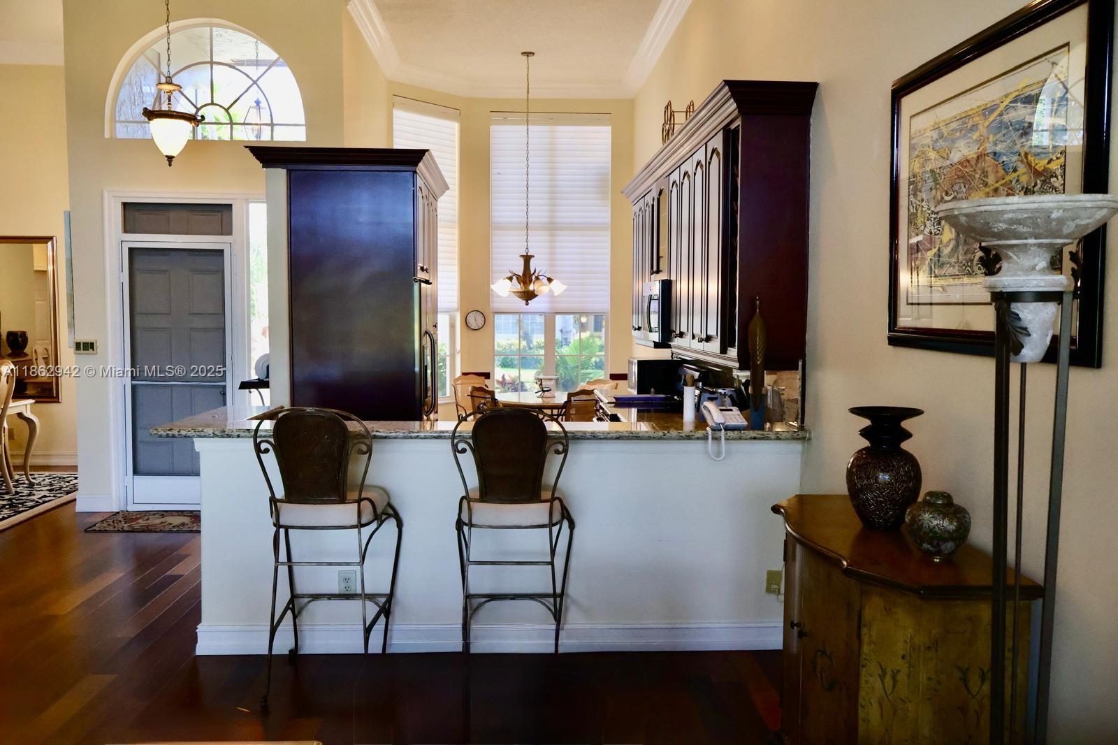 17246 Boca Club Boulevard, Unit 102 Boca Raton, FL 33487 - Photo 10 of 50 a view of dining room and kitchen with furniture wooden floor and chandelier