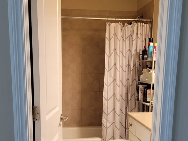 a bathroom with a shower curtain and a window