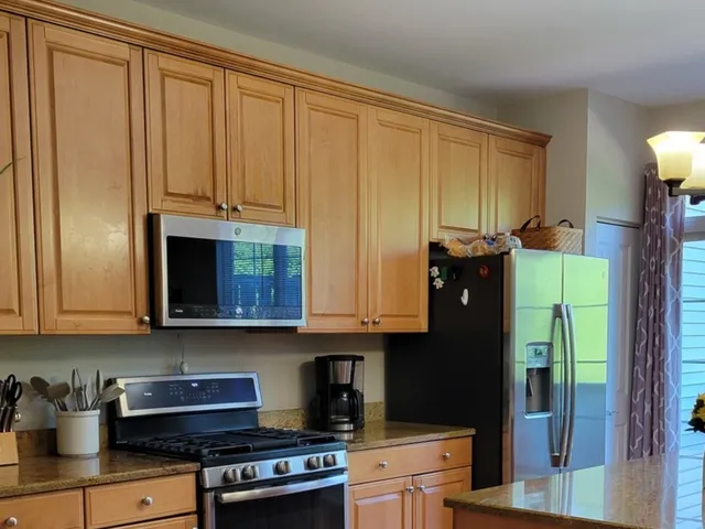a kitchen with stainless steel appliances granite countertop a refrigerator and a stove top oven