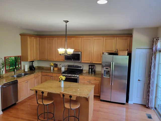 a kitchen with kitchen island a counter top space appliances and cabinets