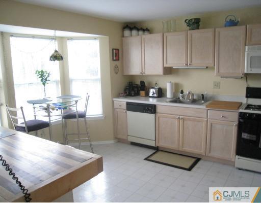 1419 Plymouth Road North Brunswick, NJ 08902 - Photo 2 of 9 a kitchen with stainless steel appliances granite countertop a stove a sink and white cabinets