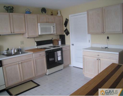1419 Plymouth Road North Brunswick, NJ 08902 - Photo 3 of 9 a kitchen with cabinets appliances and a sink