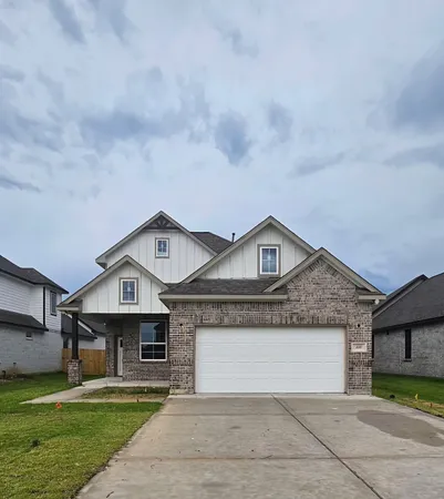 a front view of a house with a garden and yard