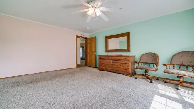 a living room with furniture a flat screen tv and a refrigerator