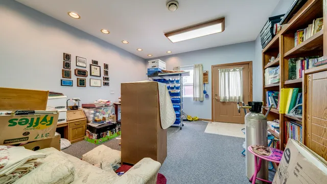 a view of an empty room with wooden floor and a kitchen