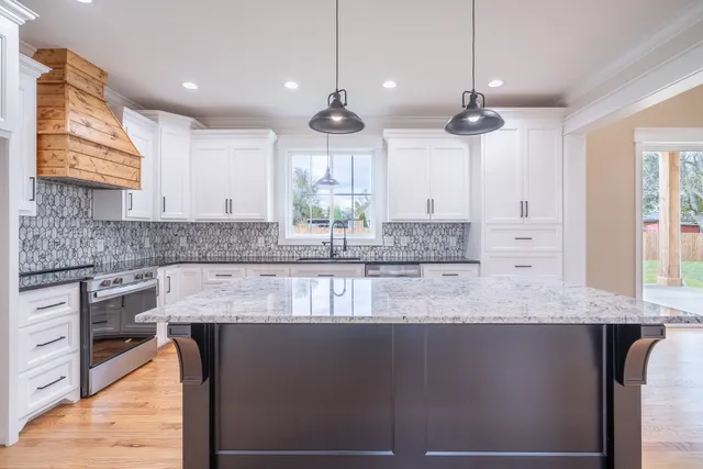 a kitchen with stainless steel appliances granite countertop a stove and wooden floor