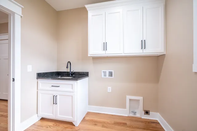 a bathroom with a granite countertop double vanity sink and two mirror