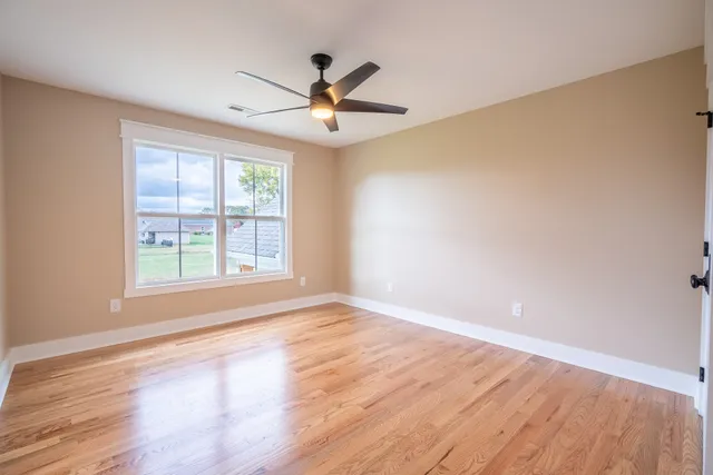 a view of a livingroom with wooden floor and a ceiling fan