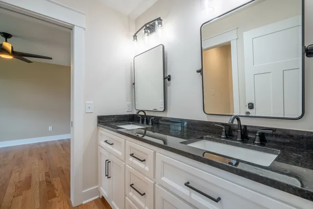 a bathroom with a granite countertop sink a toilet and shower