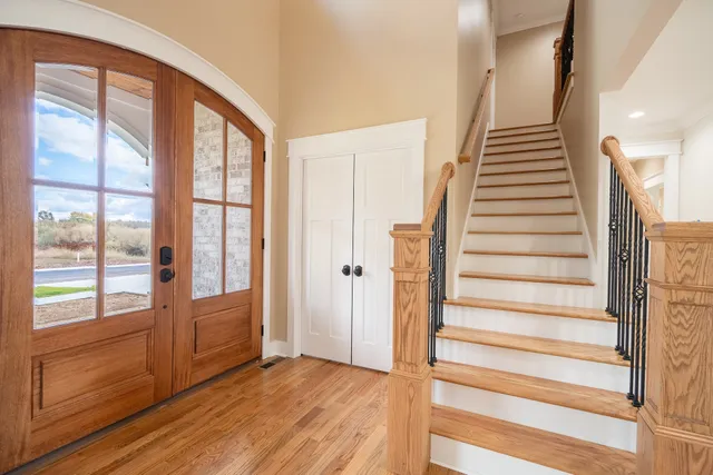 a view of a hallway with wooden floor and staircase