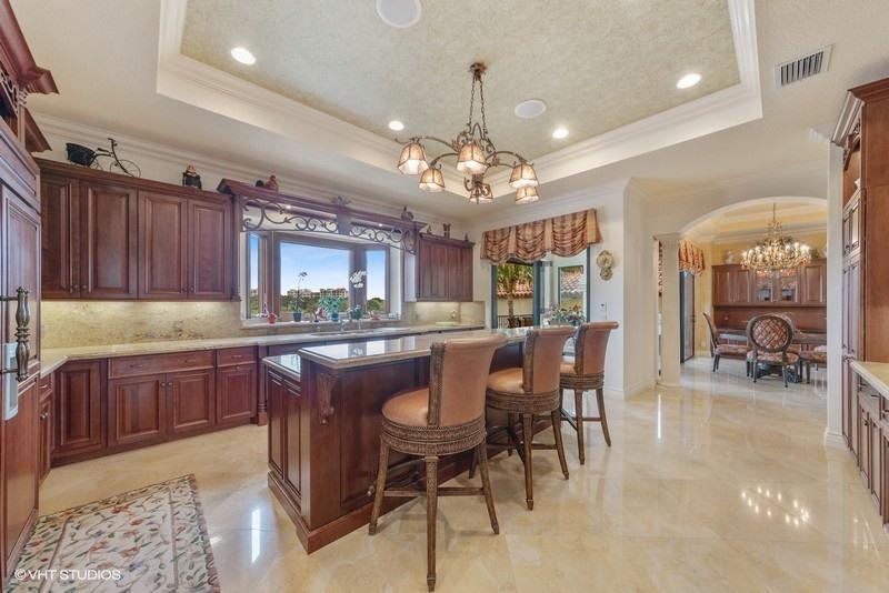 16904 Passage South Jupiter, FL 33477 - Photo 8 of 22 a kitchen with a dining table chairs cabinets and stainless steel appliances