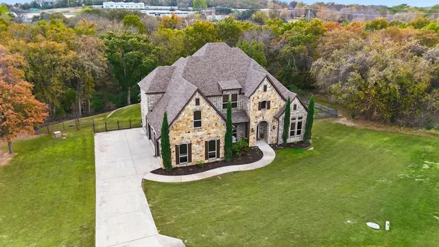a aerial view of a house with swimming pool garden and tall trees