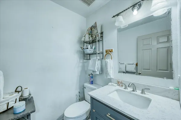 a bathroom with a sink vanity mirror and toilet