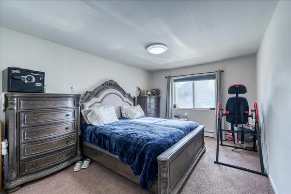 a bed sitting in a bedroom next to a window with a chandelier
