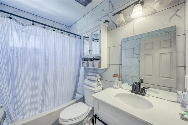 a bathroom with a sink toilet and shower