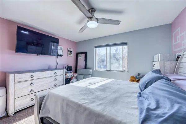 a bedroom with a bed a window and dresser