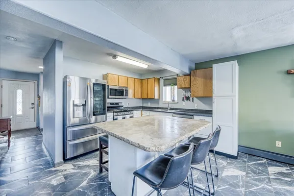 a kitchen with granite countertop a table and chairs in it