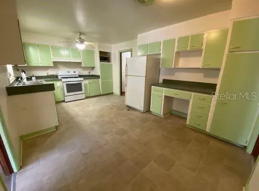 a kitchen with a refrigerator sink and stove top oven