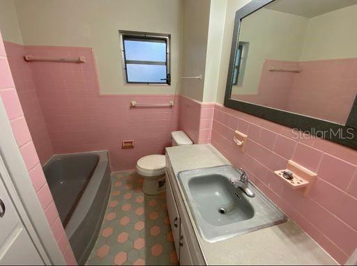 930 Northwest 36th Avenue Gainesville, FL 32609 - Photo 7 of 9 a bathroom with a sink a toilet and mirror