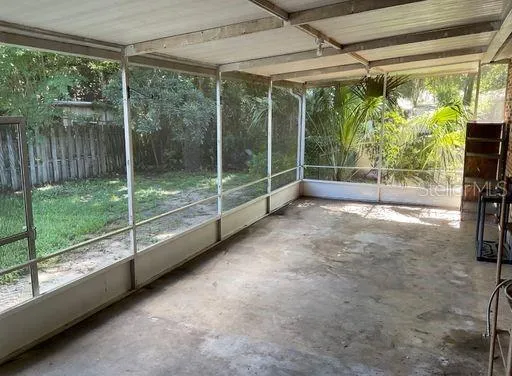 a view of empty room with floor to ceiling window and tree