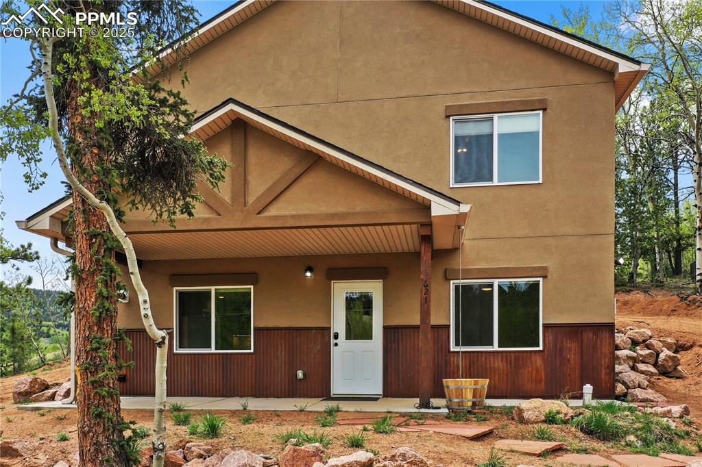 View of front of house with a porch and stucco siding
