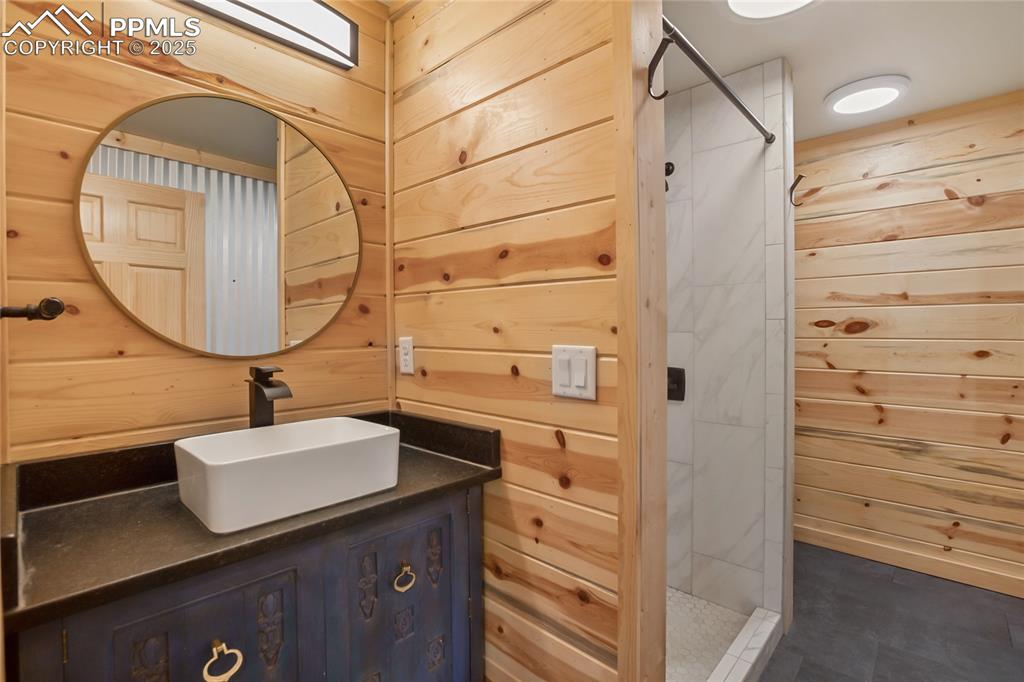 621 Yorktown Road Cripple Creek, CO 80813 - Photo 14 of 29 Main level full bathroom with wood walls, vanity, and a walk in shower