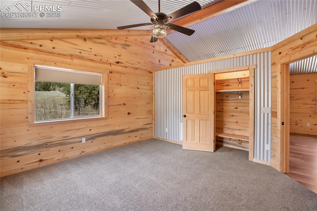 621 Yorktown Road Cripple Creek, CO 80813 - Photo 18 of 29 Bedroom #3 with pine paneling, metal accents, carpet floors and ceiling fan