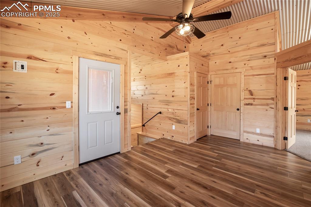 621 Yorktown Road Cripple Creek, CO 80813 - Photo 24 of 29 Upstairs walk out family room featuring pine paneling, LVP flooring, and a ceiling fan