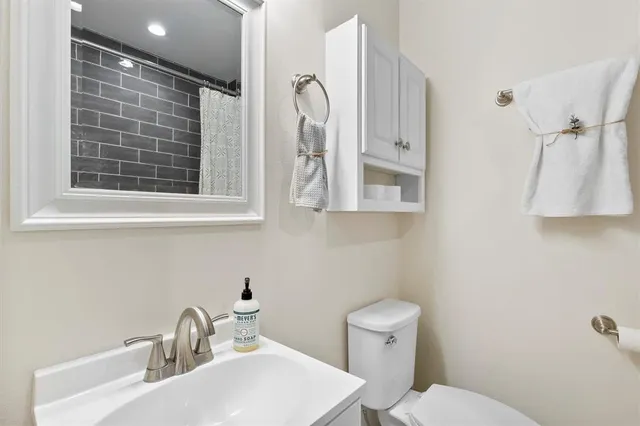 a bathroom with a toilet sink and mirror