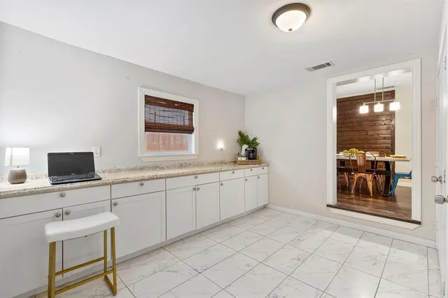 a spacious bathroom with a granite countertop sink a mirror and a bathtub