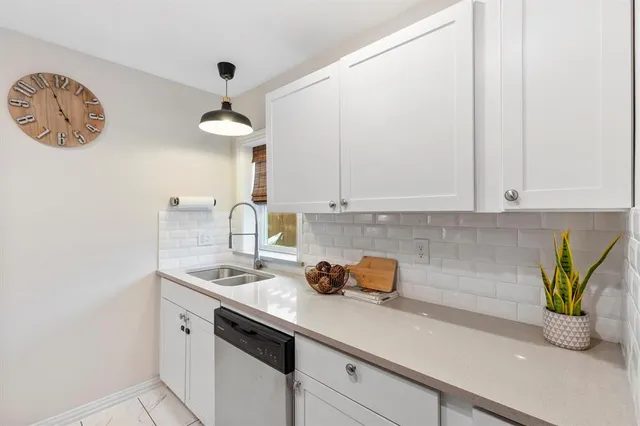 a kitchen with stainless steel appliances a white cabinets a sink and a stove