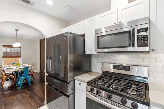 a kitchen with stainless steel appliances a stove a microwave and a refrigerator