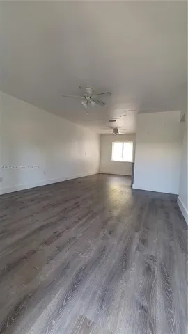 a kitchen with granite countertop a stove top oven a sink dishwasher and a microwave oven on the wooden floor