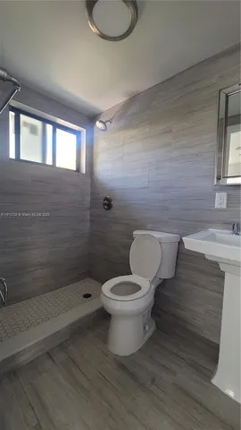 a bathroom with a toilet a sink and mirror