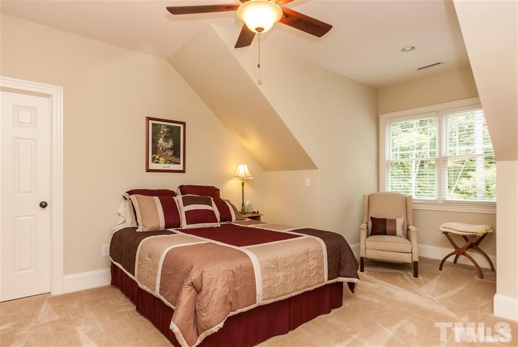 5515 Strathmore Drive Raleigh, NC 27613 - Photo 14 of 25 a bedroom with a bed and a chandelier