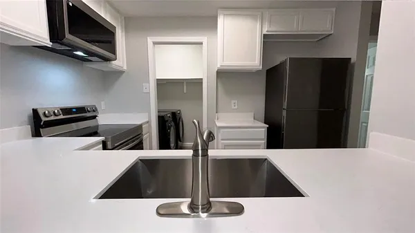 a kitchen with a refrigerator and a stove top oven
