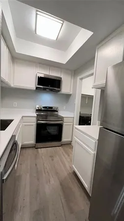 a kitchen with stainless steel appliances a stove a microwave and white cabinets